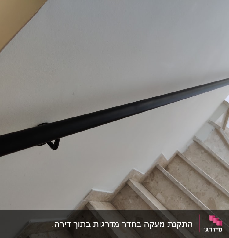 מעקה שחור מותקן לאורך גרם מדרגות פנימי